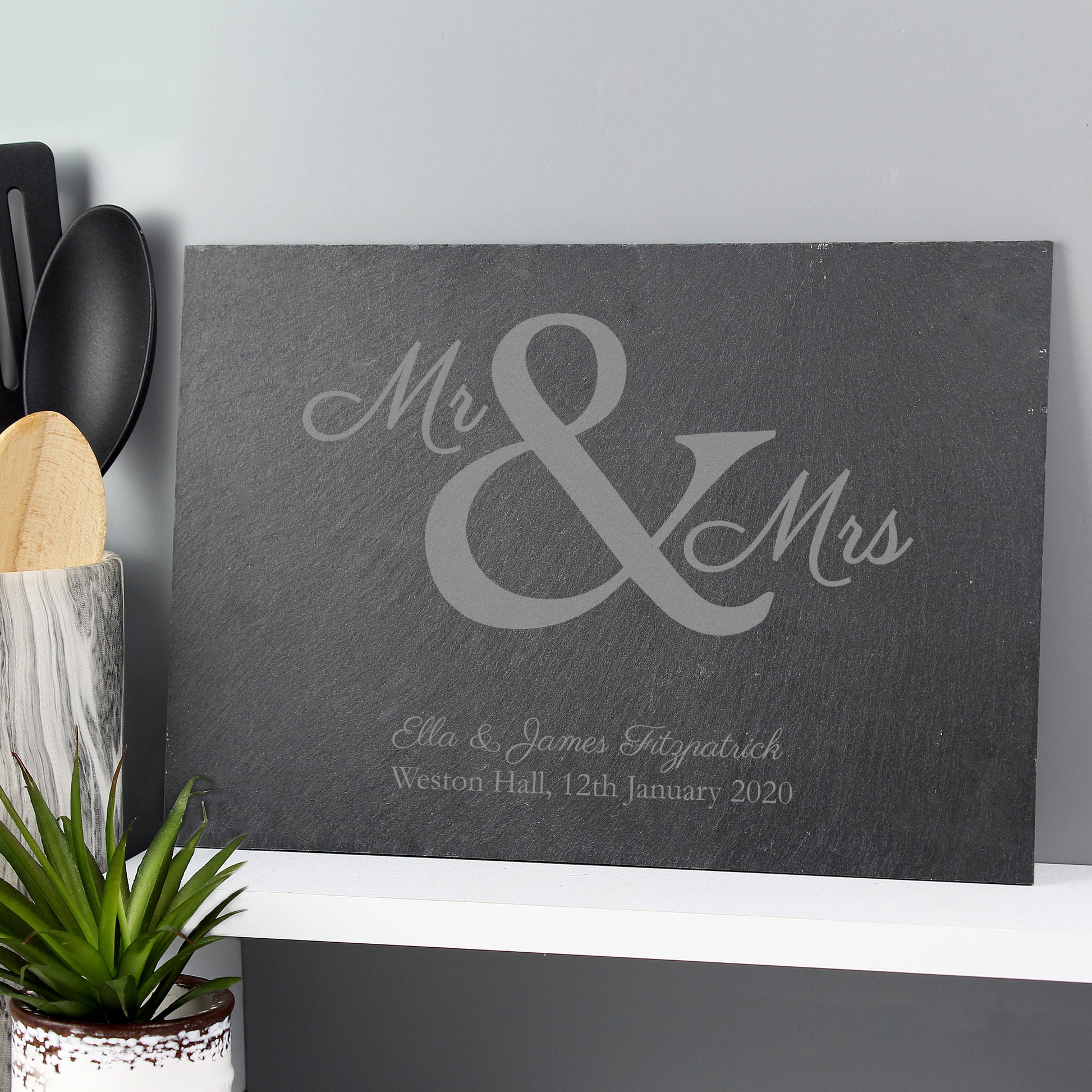 a slate board or placemat etched with mr & mrs with wedding details below.